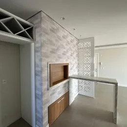 Parede texturizada com nicho de madeira em um ambiente interno.