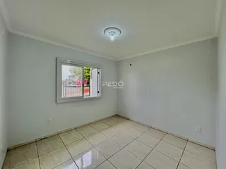 Ambiente interno de uma sala com piso de cerâmica e janela.