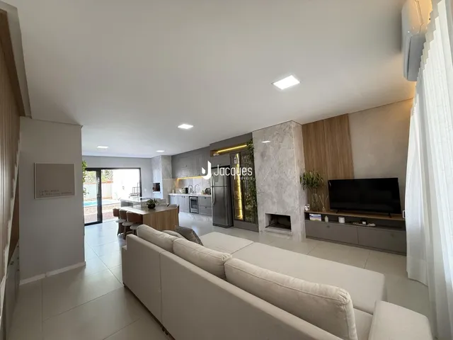 Sala de estar moderna com piso claro e decoração contemporânea.