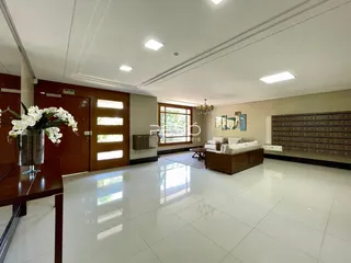 Sala de estar ampla com piso de cerâmica clara e decoração moderna.