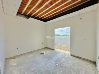 Interior de um cômodo com paredes brancas e piso de concreto.