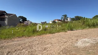 Vista da fachada de uma residência em Lajeado, Brasil, com vegetação alta na frente.