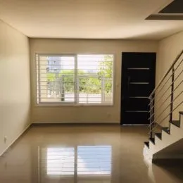 Interior com grande janela e escadaria em um imóvel.