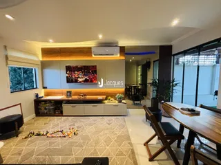 Sala de estar moderna com painéis de madeira e televisão.