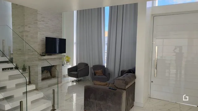 Sala de estar com lareira e escadaria em um imóvel.
