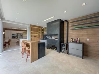 Sala de estar com lareira e cozinha integrada em um ambiente moderno.