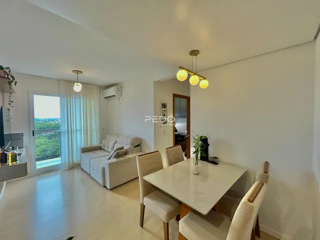 Sala de estar com piso de madeira clara e mesa de jantar.