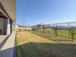 Fachada de uma residência com jardim e cerca.