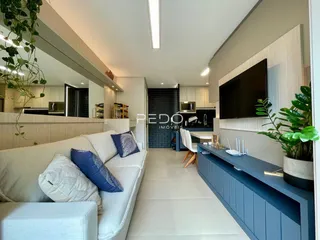 Sala de estar com cozinha integrada e decoração moderna.