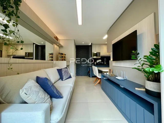 Sala de estar com cozinha integrada e decoração moderna.