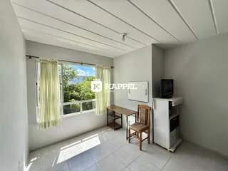 Uma sala de estar clara com janela e piso de cerâmica.