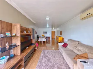 Sala de estar com piso de madeira e móveis de madeira.