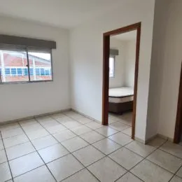 Foto de um ambiente interno com piso de cerâmica clara e paredes brancas.
