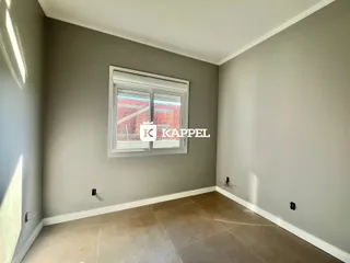 Foto de um cômodo interno com paredes cinzas e uma janela grande.