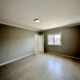 Hall de entrada com piso de cerâmica e paredes neutras.