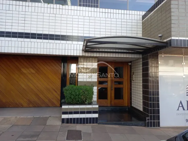 Fachada de um imóvel com revestimento de azulejos brancos e porta de madeira na entrada.