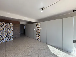 Corredor com parede decorativa e piso de cerâmica.