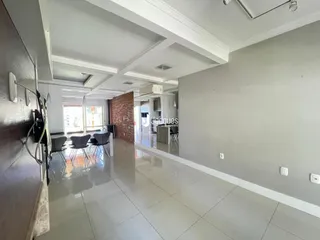 Sala de estar com piso de cerâmica e paredes cinzas em um imóvel no Brasil.