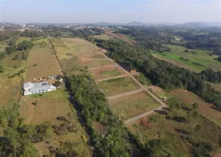 Vista aérea de um terreno rural com áreas de vegetação e construções.