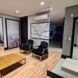 Sala de estar com piso de madeira clara e teto branco.