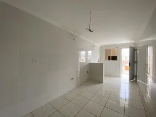 Hall de entrada com paredes brancas e piso de porcelanato claro.