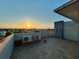 Vista de uma área externa com piso de concreto e aparelhos de ar condicionado em Lajeado.