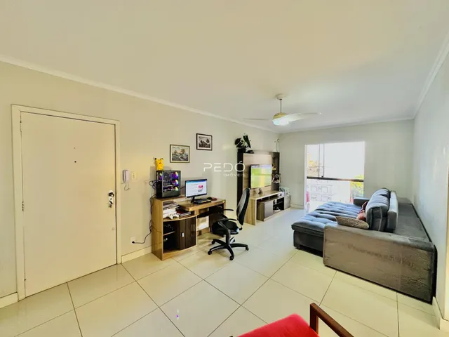 Sala de estar com sofá e área de trabalho em um imóvel no Brasil.