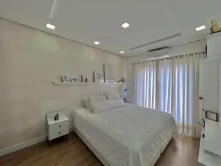 Quarto com cama e janela em ambiente claro.