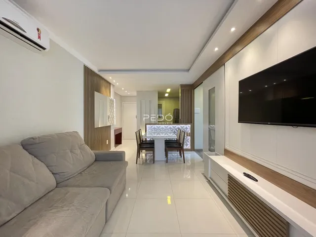 Sala de estar moderna com sofá e televisão em um apartamento.