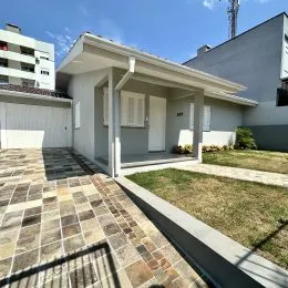 Fachada de uma residência em Lajeado, Brasil, mostrando a entrada coberta e o jardim frontal.