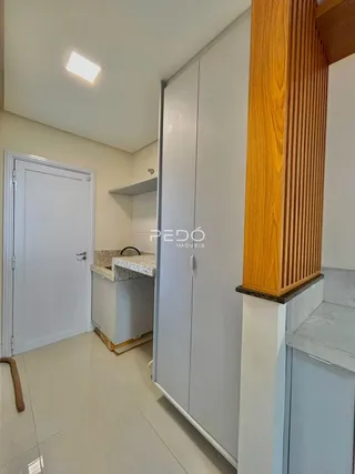 Vista interna de um corredor com portas brancas e piso claro.