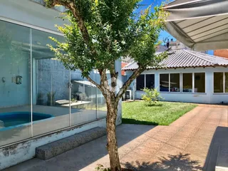 Fachada de imóvel em Lajeado, Brasil com jardim e área de piscina.