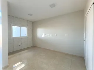 Esta é uma foto de uma sala com piso de cerâmica clara e parede de tijolos brancos.