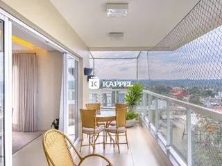 Sala de estar com móveis de vime e vista panorâmica da área externa.