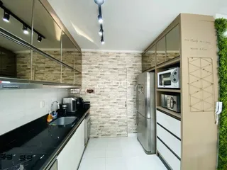 Foto de uma cozinha moderna com armários e bancadas escuras.