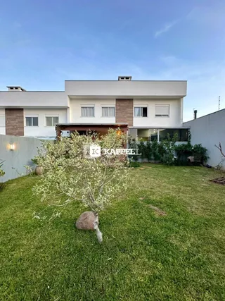 Foto da fachada de uma casa moderna com um jardim gramado em Lajeado.