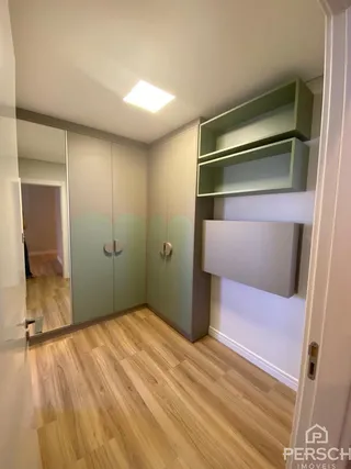 Quarto com armários embutidos e piso de madeira clara.