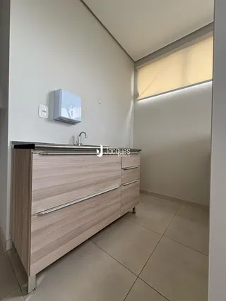 Foto de um banheiro moderno com bancada de madeira e louças sanitárias.