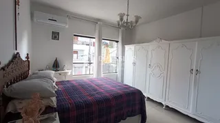 Quarto com armários brancos e cama decorada.