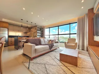 Sala de estar moderna com grandes janelas e vista da cidade.