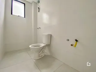 Foto de um banheiro com piso e louças brancas.