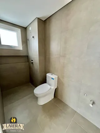 Foto do interior de um banheiro com piso e paredes de cerâmica.