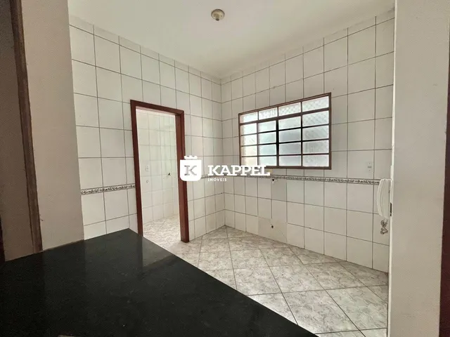 Foto de um cômodo interno com paredes brancas e piso de azulejos claros.