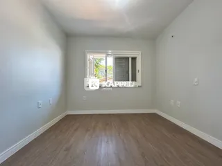 Foto de um cômodo interno com piso de madeira e janela.