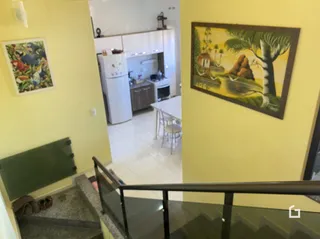 Interior de uma sala com paredes amarelas e piso de cerâmica.