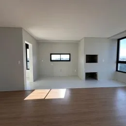 Foto de um cômodo interno vazio com piso de madeira e janela.