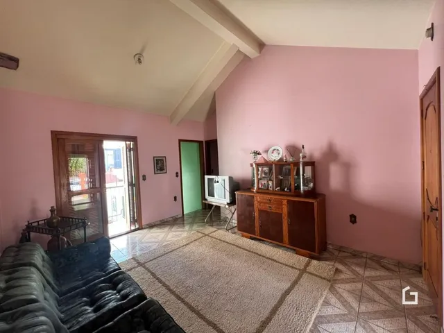 Sala de estar com paredes rosa e piso de cerâmica.