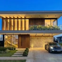 Fachada moderna de uma residência com revestimento de madeira e grandes janelas em Lajeado, Brasil.