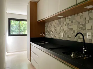 Vista da cozinha moderna com armários de madeira e bancada escura.