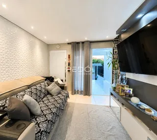 Sala de estar com sofá e televisão em um imóvel no Brasil.
